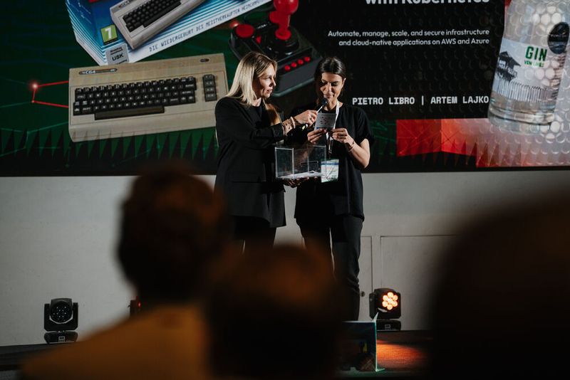 Lydia Hundsdörfer und Jessica Seifert (v.l.) von der Vogel IT-Akademie ziehen die Gewinner der Cloud Native Challenge. (Bild: Manuel Emme Fotografie / Vogel IT-Akademie)