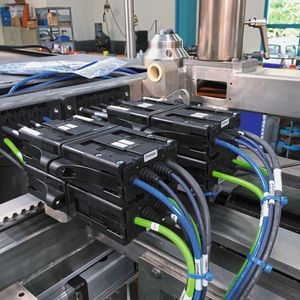 Module Connect im Einsatz: Die hier gezeigte Brotverpackungsmaschine arbeitet mit hohen Hubzahlen auf kompaktem Bauraum. Deswegen setzten die Entwickler für eine zuverlässige Leitungsführung auf E-Ketten und Chainflex-Leitungen von Igus. Mit Module Connect lässt sich das System einfach anschliessen.  (Bild:  Igus)