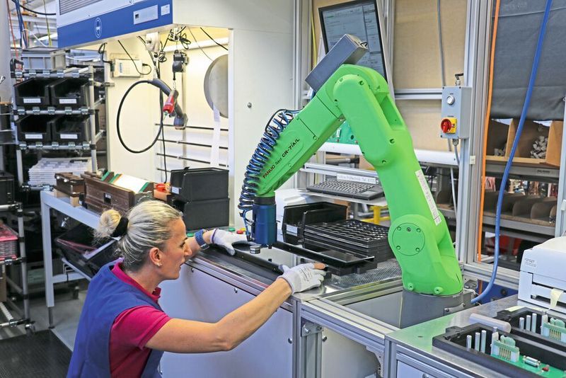 Pas de crainte de contact : l'employée de montage apprécie le soutien de son nouveau collègue vert, répondant au doux nom de Fanuc CR-7iA/L.  (Fanuc)