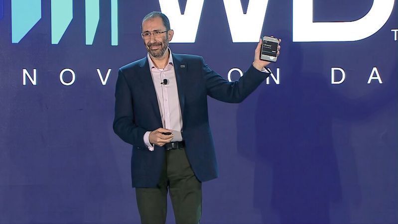 Alter Formfaktor, neue Technologien: Ahmed Shihab, Chief Product Officer bei Western Digital, zeigt auf dem Innovation Day das physische Laufwerk, das bis zu 140 TB fassen soll.(Bild:  Western Digital)