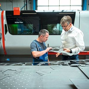 Franz Langen (r.) überzeugt sich im Gespräch mit einem Maschinenbediener von der hohen Qualität der Schneidkanten.(Bild:  Daniel Kunzfeld/Bystronic)