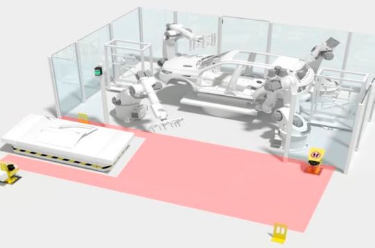 Der gesamte Übergabebereich (vorne) wird per Sicherheits-Laserscannern überwacht. Der Zugang oder die Anwesenheit von Personen werden erkannt, der Umriss des fahrerlosen Transportfahrzeugs bei der Durchfahrt dynamisch ausgeblendet.(Bild:  Leuze Electronic)