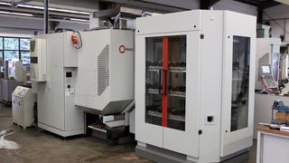 Bild 1: Die Übergabeposition des Werkstück- und Paletten-Handhabungssystems befindet sich mittig vor dem CNC-Bearbeitungszentrum.  (Bild: Hermle)