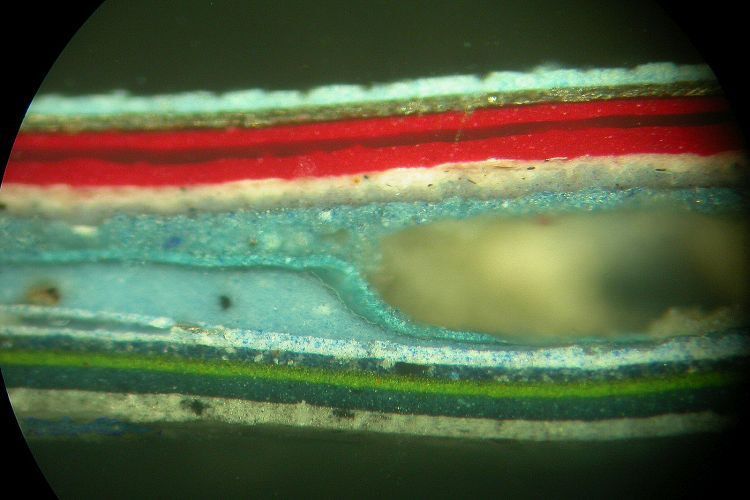 Ein Querschliff unter dem Mikroskop: Deultich erkennt man die Farblacke und Grundierungen etc. und ihre Dicke. Auch Einschlüsse wie Schmutzpartikel oder in diesem Fall eine Blase (Bildmitte bis rechts) werden hier sichtbar. (Gundula Tutt)