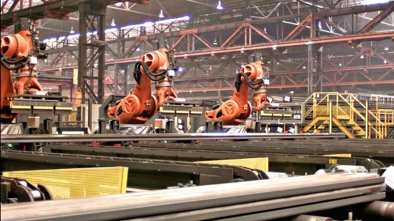 Das Handling der Spezialprofile war eine große Herausforderung für die sechs Roboter von Kuka. Als erste ihrer Art sollten sie Stahlstangen mit einer Länge bis 26 m und einem Gewicht von rund 2,5 t transportieren. (Kuka)
