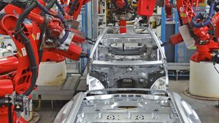 Beim Anbringen und Befestigen von Karosserieteilen bilden Roboter ein Spalier. Sie stehen in dichten Reihen nebeneinander und schweißen, nieten, falzen, bringen Bolzen und manches mehr – teilweise in parallel laufenden Prozessen. (Bild: Comau)