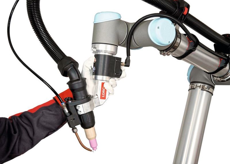 Die für das „Teachen“ der Cobotbewegungen benötigte Free-Drive-Funktion ist bei diesem WIG-System gut zugänglich platziert – und zwar direkt an der Brennerhalterung. (Lorch)