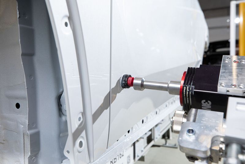 Software speichert die exakte Lage, Form und Größe des Fehlers, konstruiert ein digitales 3D-Abbild und ordnet es basierend auf objektiven Kriterien ein. Die Roboter arbeiten an jeder Karosserie individuell. (Bild: Harry Zdera/BMW)