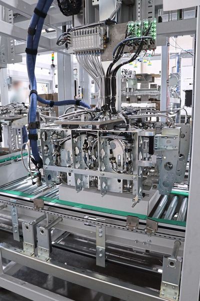 Der Deckelaufleger beinhaltet die Kartonminimierung, eine Druck- und eine Etikettiereinrichtung. Hier werden die Laschen eingeschlagen und mit Leim versehen.  (Bild: SEW-Eurodrive)