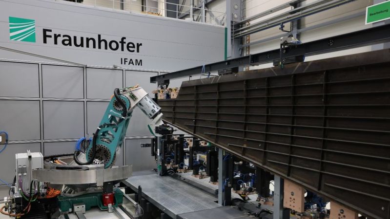 Die neuentwickelte flexible Fräskinematik auf einer Linearachse bearbeitet hochpräzise ein CFK-Flugzeugseitenleitwerk im 1:1-Maßstab im Fraunhofer IFAM in Stade.(Bild:  Fraunhofer IFAM)
