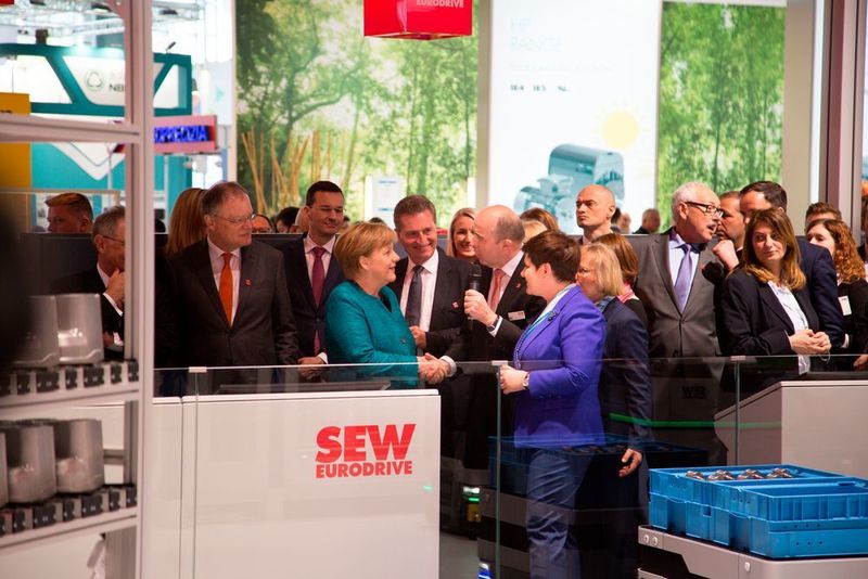 Merkel am Messestand von SEW. Geschäftsführer Johann Soder betonte im Gespräch mit der Kanzlerin: „Es freut uns sehr, dass unser Engagement auch von Seiten der Politik gewürdigt wird.“  (SEW-Eurodrive)