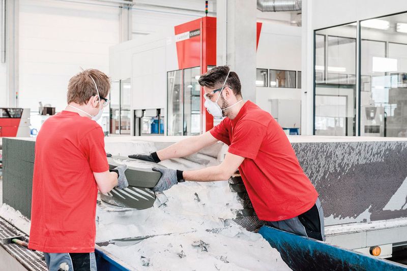 Mitarbeiter entpacken die Formen nach dem Druck auf der VX4000 und befreien sie von überschüssigem Sand. (Voxeljet)