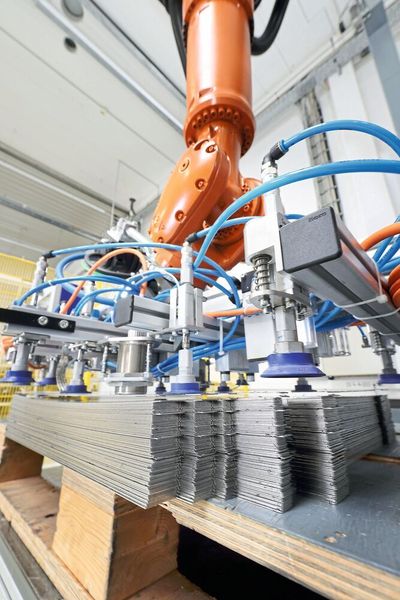 Der Roboter greift mit einem Sauggreifer das Bauteil vom Stapel auf. (Kuka)