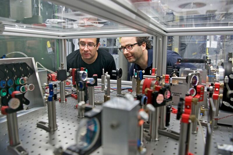 Karsten Schuhmann (l.) und Aldo Antognini an dem Lasersystem, das für die Laserspektroskopie eingesetzt wurde. (Paul Scherrer Institut/Markus Fischer)