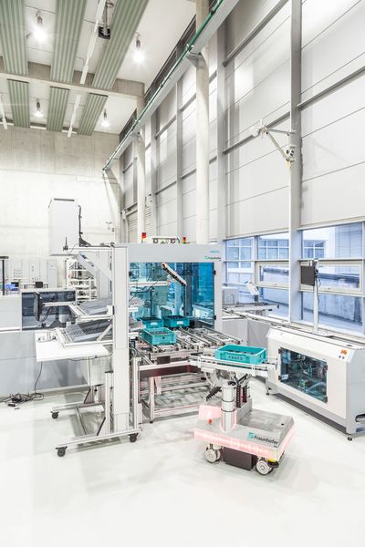 Mithilfe interner und externer Lokalisierungssensoren können sich Fahrerlose Transportsysteme (FTS) zum Beispiel bei der Übergabe von Lasten bis in den Millimeterbereich genau positionieren. (Fraunhofer-IPA/Rainer Bez)