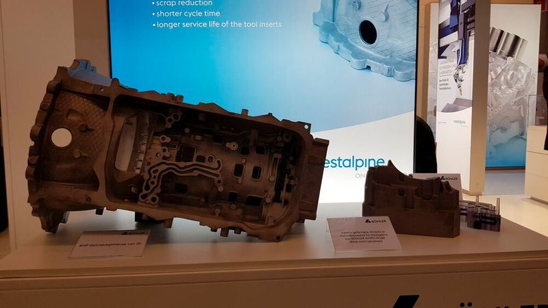Voestalpine Böhler Edelstahl bietet Stähle für Druckgusswerkzeuge sowohl als Blöcke als auch in Pulverform an. Aus den Pulvern können Werkzeugeinsätze im Lasersintern additiv gefertigt werden. Hier ein hybrider Einsatz (Vollmaterial + additive Fertigung) für die Parksperre (rechts) eines Getriebegehäuses (links). (Bild: D.Quitter/VCG)