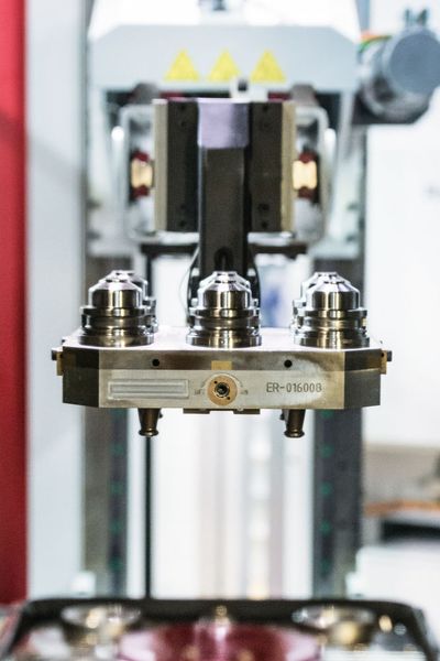The robot with the long telescopic X-axis feeds the machine with new workpieces to be machined. The UPC palletizing system positions the workpiece carriers with a repeatability of less than 0.003mm. (Erowa)