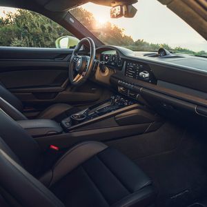 Der Handschalter ist mit dem Facelift Geschichte und statt eines echten Wählhebels ragt für die Automatik nur noch ein kleiner Stummel aus der aufgeräumten Konsole.(Bild:  Porsche)