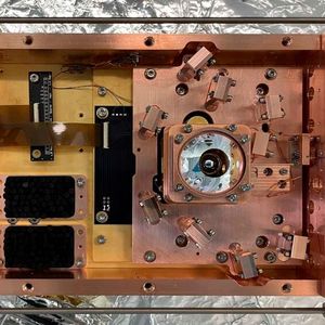Aufsicht auf den Versuchsaufbau: Die Chip-Falle, in der die Versuche stattfanden, befindet sich in dem Behälter unterhalb des runden, silberfarbenen Objektivs.(Bild:  Tobias Sägesser / ETH Zürich)