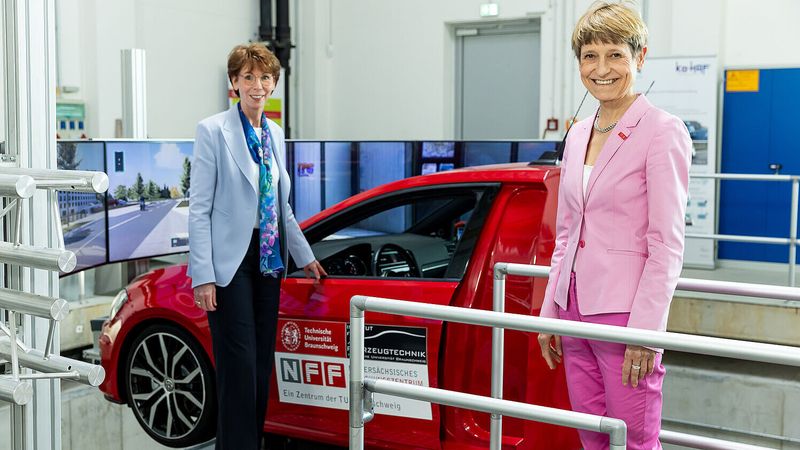 Hauke Stars, Konzernvorständin für IT der Volkswagen Group (links), und Professorin Dr. Angela Ittel, Präsidentin der TU Braunschweig, am dynamischen Gesamtfahrzeugsimulator des NFF (Niedersächsisches Forschungszentrum Fahrzeugtechnik).(Bild:  Philipp Ziebart/TU Braunschweig)