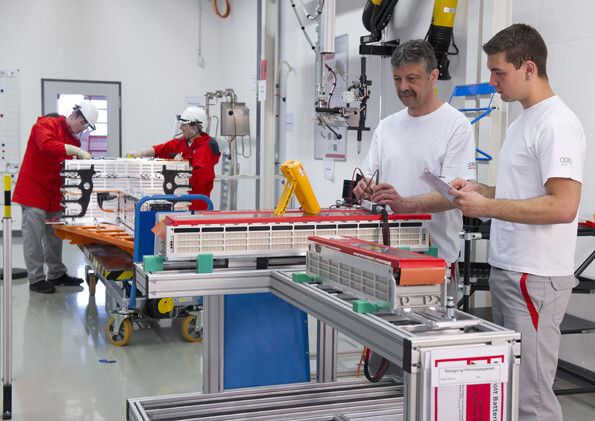 Vordergrund: Prüfung Spannungsabgriffe von Batteriezellen. Hintergrund: Elektrische Endmontage einer R8 e-tron Batterie. (Bild: Audi AG)