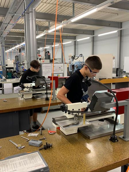 Apprentis en pleine concentration sur une décolleteuse. (Source : CAAJ Moutier)