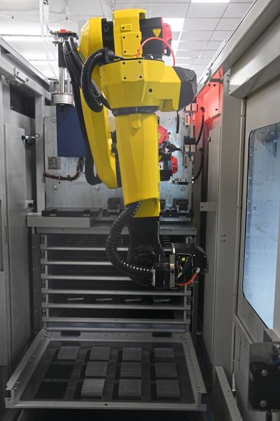 Der Roboter samt R-C2-Modul nimmt das per R-C2-Zentrischpanner fixierte Bauteil aus dem Fach.  (Bild: Gressel)