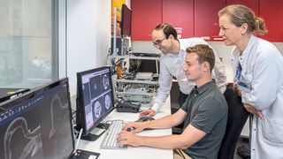 Dimitrios Karampinos, Professor für Experimentelle Magnetresonanztomographie beim Besprechen von MRT-Bildern mit PD Dr. Eva Maria Fallenberg und Jonathan Stelter.  (Bild: Andreas Heddergott / TU München)