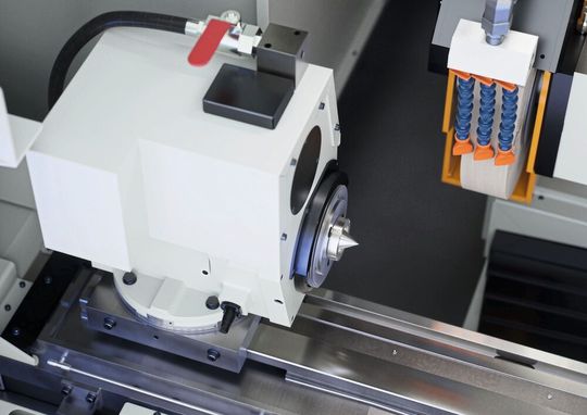 Kompakter Werkstückspindelstock mit präzisen Kegelrollenlagern für Rundheitsgenauigkeiten bis 0,5 µm. Der Schwenkbereich von 0 bis +30° ermöglicht flexible Bearbeitungsstrategien.(Bild:  Emag)