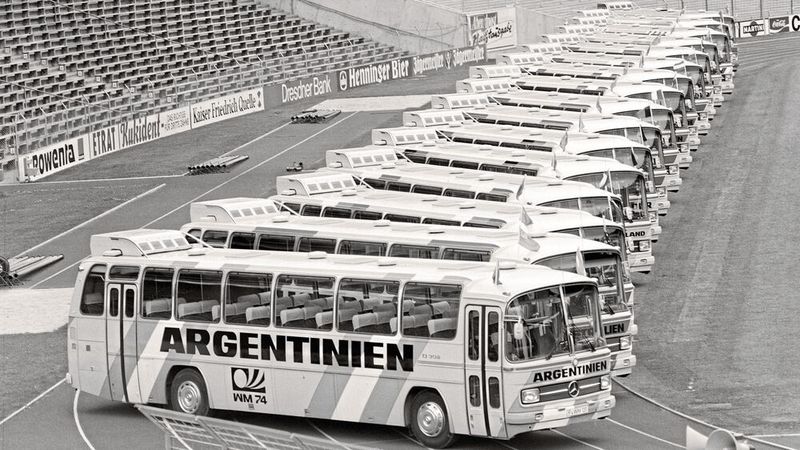 16 Nationen nehmen an der WM 1974 teil, und allen stand für sämtliche Fahrten jeweils ein O 302 zur Verfügung, mit den Landesnamen und -farben versehen. Oben auf dem Dach flatterten außerdem Fähnchen der jeweiligen Mannschaft im Wind. (Bild:  Mercedes-Benz AG)