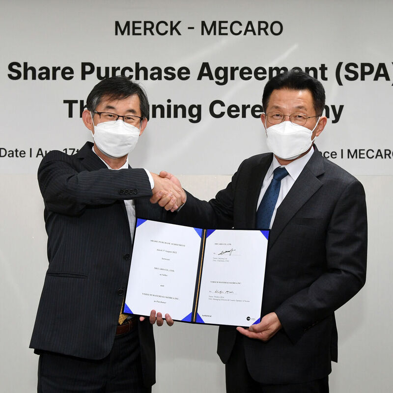 Woo Kyu Kim (links) von Merck und Jae Jung Lee von Mecaro bei der Unterzeichnung.