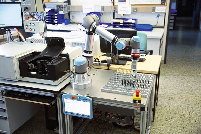 Im Glaslabor des Schott-Forschungszentrums in Mainz unterstützt eine kollaborative Applikation von OnRobot bei der Qualitätsprüfung: Sie bestückt ein hochempfindliches Messgerät mit Probengläsern.  (Schott / OnRobot)