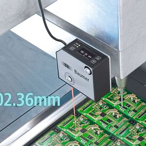 Laser-Distanzsensoren ermöglichen die wiederholgenaue und präzise Positionierung von Werkzeugen auf einer Vielzahl von Oberflächen, wie z.B. glänzenden PCB-Substraten oder metallischen Oberflächen. (Bild:  Baumer)