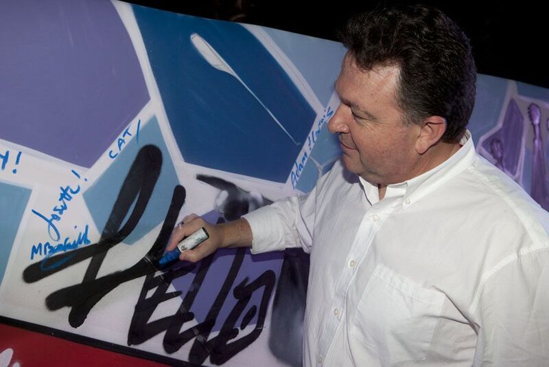 Autotask-CEO Mark Cattini beim Signieren der Graffitiwand. (Autotask)