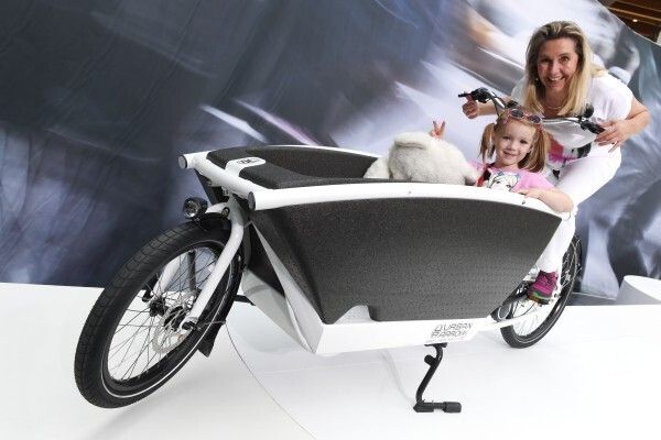Neuheiten Eurobike 2014: Lastenrad: Urban Arrow Dieses Lastenrad mit dem Frontlader ‚Convertible‘ transportiert Kinder sicher und trocken und kann mit Regenschutz oder Fliegennetz ausgestattet werden. Model: Anita Schnarrenberger mit Nichte Melissa  (Felix Kästle / EUROBIKE Friedrichshafen)