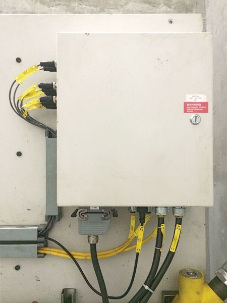 Bisher: Beim Schaltkasten des Hydraulikaggregats in der Pressengrube gab es viele Kabeldurchführungen und vor Ort zu konfektionierende Anschlüsse und die Anschlussverkabelung war komplex. (Balluff)