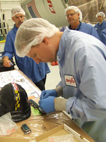 Datenlogger sind startklar: Ein Mitarbeiter von Orbital Sciences Corporation in Houston, Texas, installiert die Datenlogger auf dem Cygnus Raumfrachter. (Orbital Sciences Corporation)
