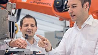 Patrick Kurer (rechts) zeigt Baumer Berater Heinz Buchegger an der Übergabestation, warum der gewählte IO-Link Sensor für diese Applikation die beste Wahl ist. (Bild: Baumer)