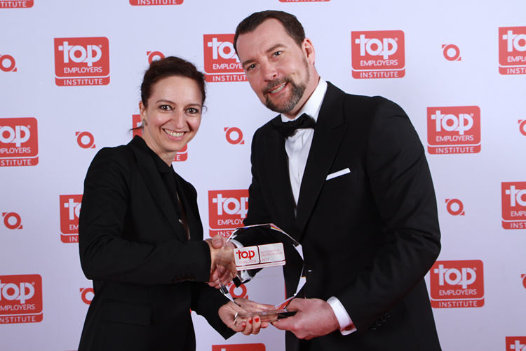 Diana Eid, Leiterin Global Recruiting bei Dräxlmaier, nimmt den Award von Steffen Neefe, Country Manager DACH beim Top Employers Institute, entgegen. (Top Employers Institute)