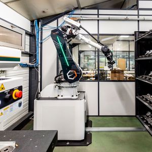 The robot handles the loading of the parts to be inspected into the storage area. Then it successively retrieves the stored pallets one by one and places them on the surface of the three-dimensional measuring machine, which is equipped with a clamping device, ensuring precise positioning and stability throughout the measurement process.(Source:  Mitutoyo)