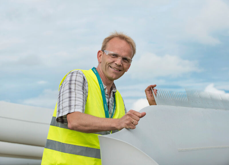 Peder Bay Enevoldsen, Siemens Wind Power in Brande / Dänemark: Dem Wind die Zähne zeigen. Was haben Dinosaurier-Schwänze mit Rotorblättern von Windturbinen zu tun? Ganz einfach: Verzahnungen an der hinteren Kante eines Rotorblattes, die wie gezackte Dino-Schweife aussehen, senken den Lärm und erhöhen die Effizienz der Windturbine – dies ist nur eine der Erfindungen von Peder Bay Enevoldsen (44) zur Optimierung von Windturbinen. Die Zähne werden entweder als Teil des Rotorblattes mitgefertigt oder können auch nachträglich aufgeklebt werden, um ältere Rotorblätter zu verbessern. Die Energieausbeute kann bis zu vier Prozent im Jahr steigen. (Siemens)