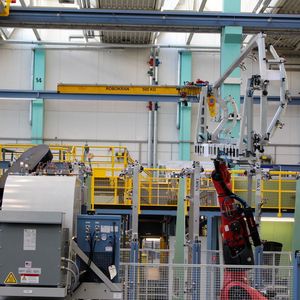 Ein Handlingroboter auf einer Linearachse führt den leeren Bauträger der Beladestation zu, damit er mit einer Schale bestückt werden kann. 