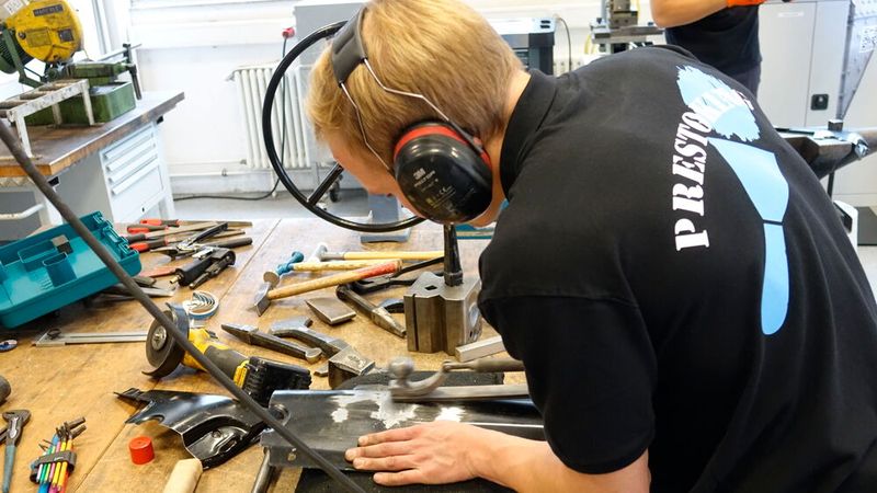 Julian Barth (Karosserieinstandhaltungstechnik) bringt die ehemals stark deformierte Stelle des Frontblechs wieder in Form. (Bild: Dominsky – VCG)