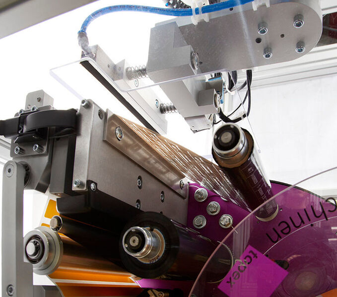 Sobald der Roboter das Etikett mithilfe der Vakuumfunktion festhält, fährt dieser vor das Coil und stoppt. (Topex)
