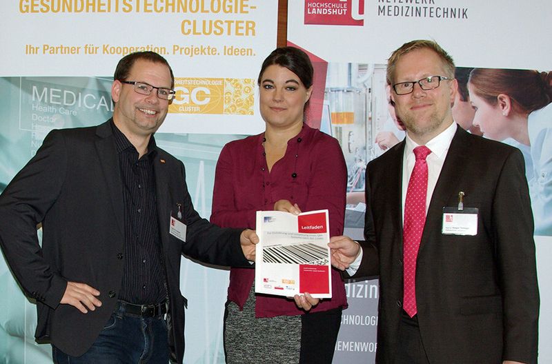 Auf dem 2. Sourcing Day des Netzwerks Medizintechnik präsentieren Patrick Pointecker vom Gesundheitstechnologie-Cluster OÖ, Caroline Eberl und Prof. Dr. Holger Timiniger vom Netzwerk Medizintechnik der Hochschule Landshut (v.l.n.r.) einen Leitfaden zur Einführung und Umsetzung eines QM-Systems in Unternehmen nach der für die Medizintechnik relevanten Norm ISO 13485. (Bild: Hochschule Landshut)