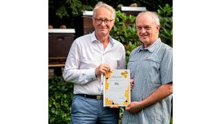 Heinrich Goller, Imker, und Dr. Bernd Pahnke, Sprecher der Geschäftsführung bei Transfracht (v. l.), bei der Übergabe der Partnerschaftsurkunde für das Bienenvolk. (Astrid Doerenbruch)