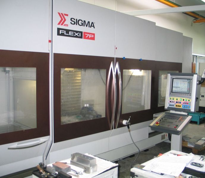 Vertikal-Bearbeitungszentrum Sigma Flexi 7P-5AX mit der Heidenhain-CNC iTNC 530. Ein Schwenkkopf mit Torque-Motor sowie ein integrierter Rundtisch mit Drehzahlen bis 60 min-1 sorgen für hohe Fertigungsflexibilität und wirtschaftliche Fünf-Achs-Bearbeitung. Ausgerüstet ist die Maschine mit zwei Paletten, eine mit Abmessungen von 1000 mm x 730 mm, die zweite Palette hat den Rindtisch mit 660 mm integriert. Mit gekoppelten Paletten können Werkstücke mit einer Länge bis 2000 mm bearbeitet werden. Das Werkzeugmagazin nimmt standardmäßig 40 Werkzeuge auf (Option sind 50 Werkzeuge).  (Bild: Kuttkat)
