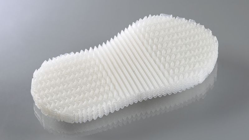 Die Sohle aus Co-Polyester-Elastomer besteht aus vielen einzelnen Folien. Die Struktur aus Rippen und Zacken sorgt für die Funktionszonen. Jede einzelne Folie weist diese Struktur auf.(Bild:  Fraunhofer CPM)