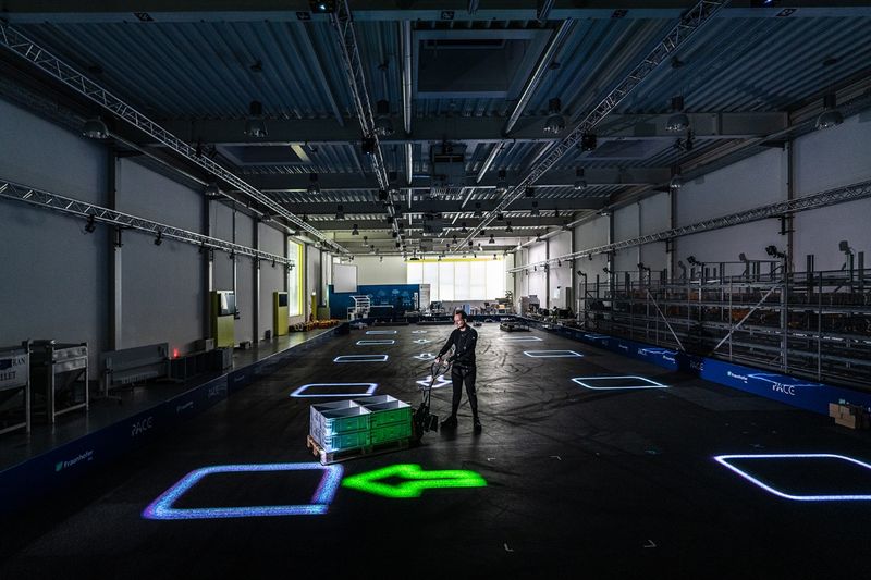 Das dynamische Leitsystem LARS wirft Informationen per Laserprojektion direkt auf den Boden der Lagerhalle.(Bild:  Fraunhofer IML)