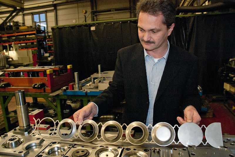 Thomas Schumacher, ein Teststreifen und das Unterteil des dazugehörigen Folgeverbundwerkzeugs: «Was uns besonders auszeichnet, ist unsere Lösungskompetenz.» (Bild: Kunrath)